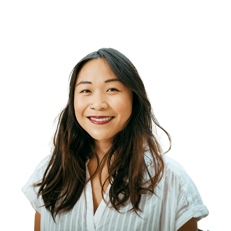 Amy Leung smiling in a white shirt against a background of large trees with a mountain range in the distance