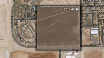 Satellite image of a plot of land for potential housing development in shades of brown and tan surrounded by residential streets