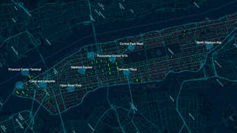 A street map of Manhattan in dark blue and green dotted with blue map points