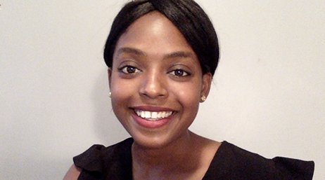 Victoria Phillips wearing a black, sleeveless blouse and smiling in front of a white background