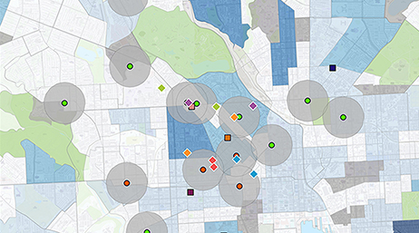 Simple city map in blue and green with scattered locations marked with multicolored dots, each with a small gray radius