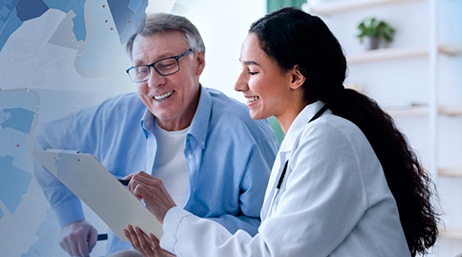 A doctor points to a spot on a paper while talking with a patient