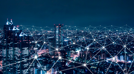 Graphic of a city brightly lit for night under a deep blue sky, overlaid with a web of glowing interconnected lines
