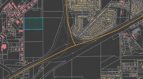 A city street map with key buildings colored yellow and pink and highway routes in gold on a dark gray background