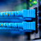 An extreme close-up photo of blue and yellow wires leading to connectors on a motherboard against a blurred blue background