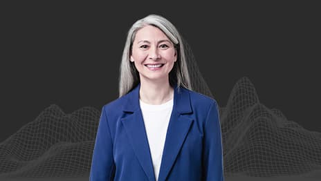 A smiling person wearing a blue blazer overlaid on a wireframe of a mountain range